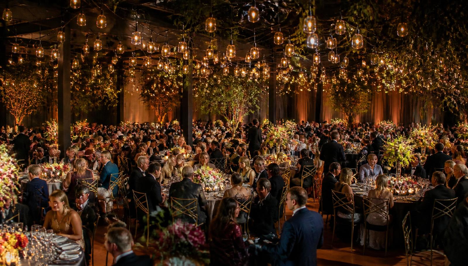 A large company celebration under warm hanging lights